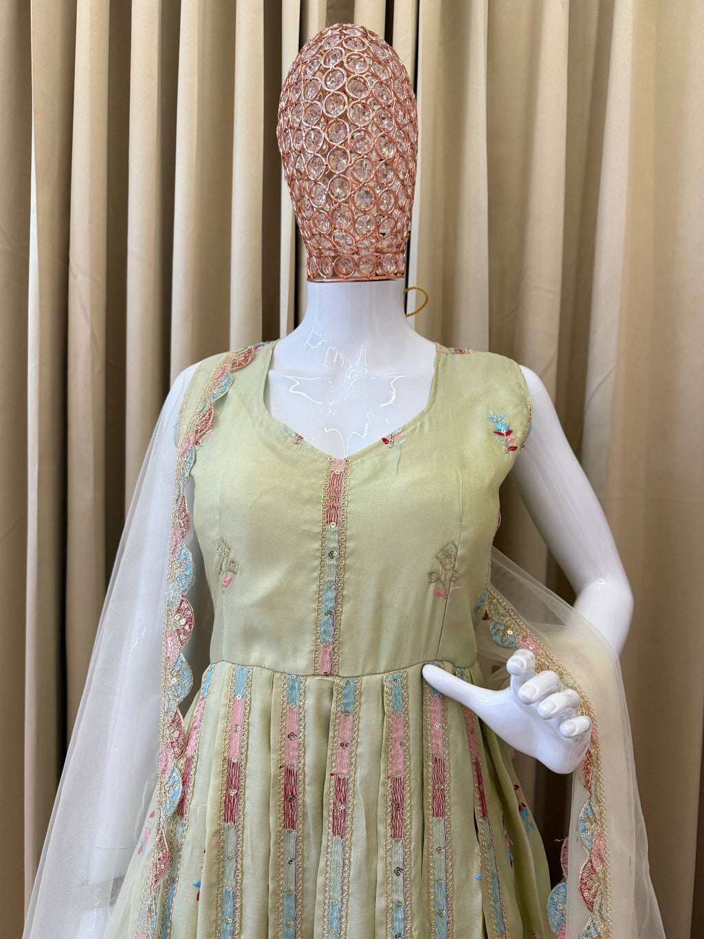 Woman in a beige, embroidered Anarkali gown.