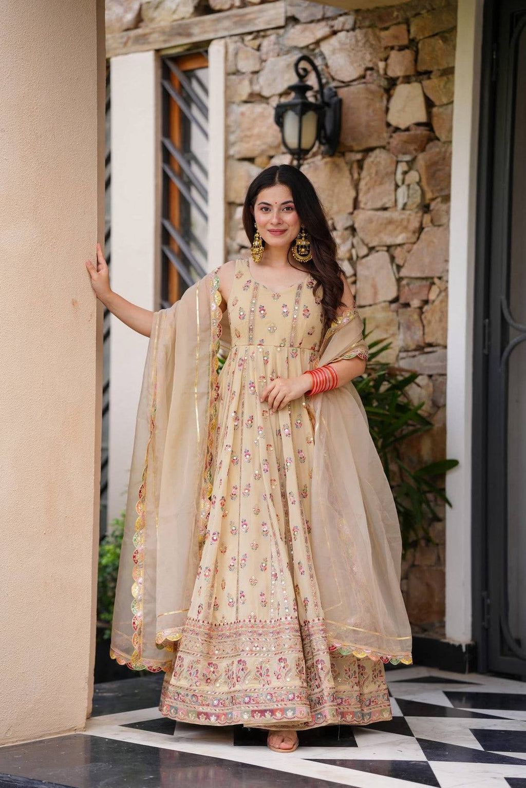 Woman in a beige, embroidered Anarkali gown.