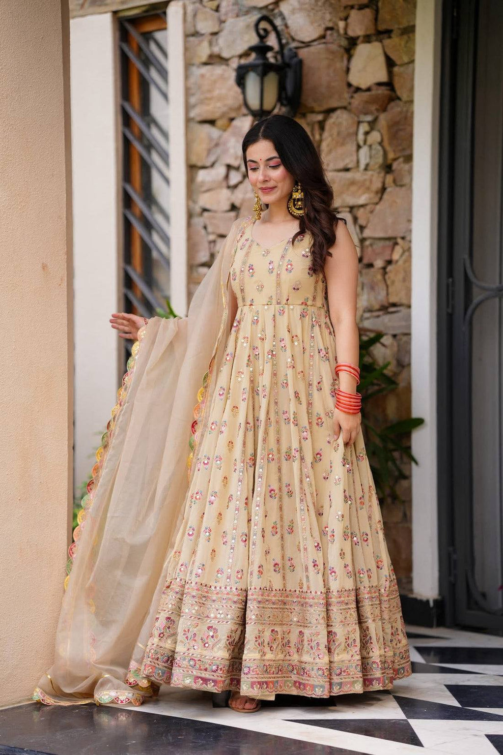 Woman in a beige, embroidered Anarkali gown.