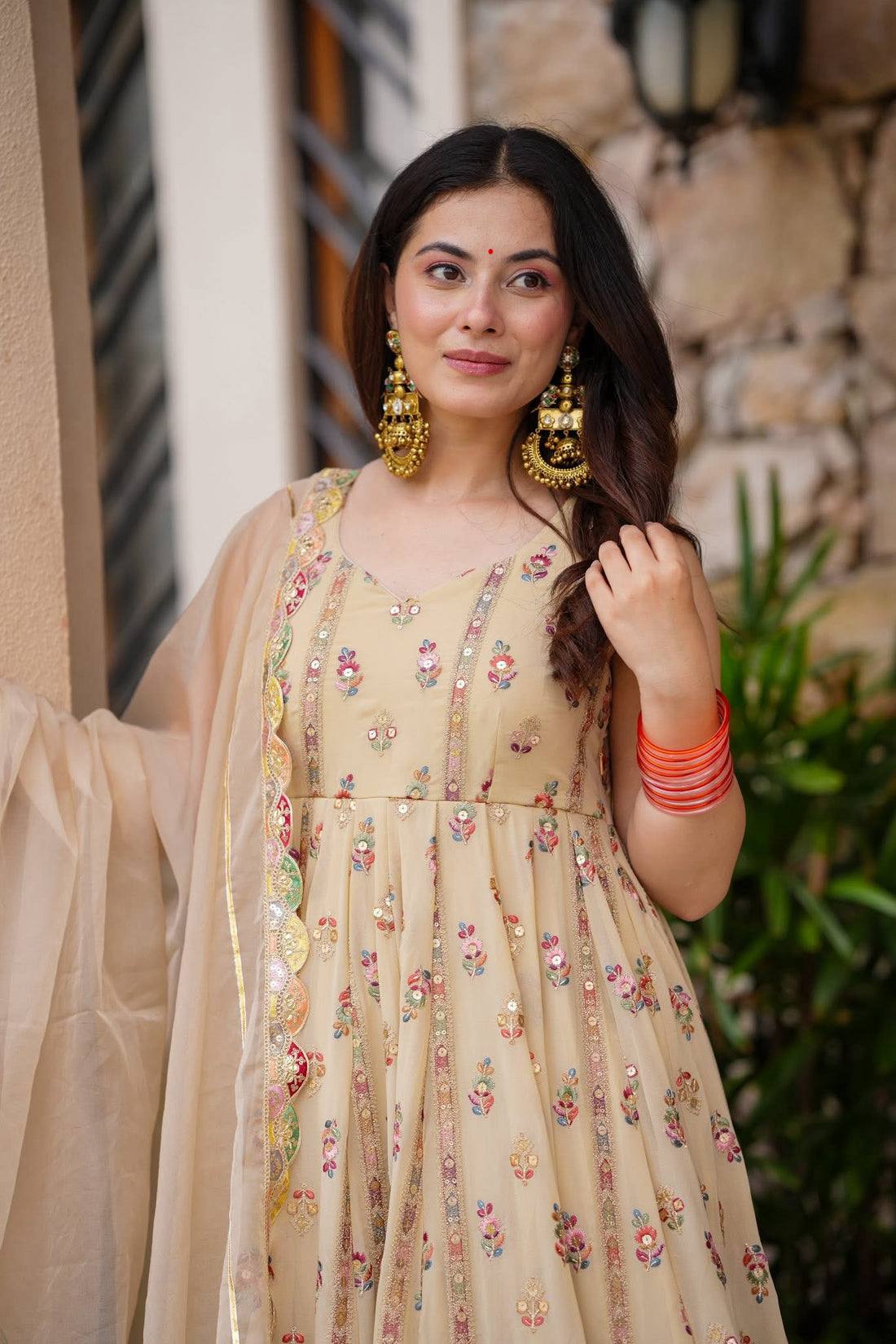 Woman in a beige, embroidered Anarkali gown.