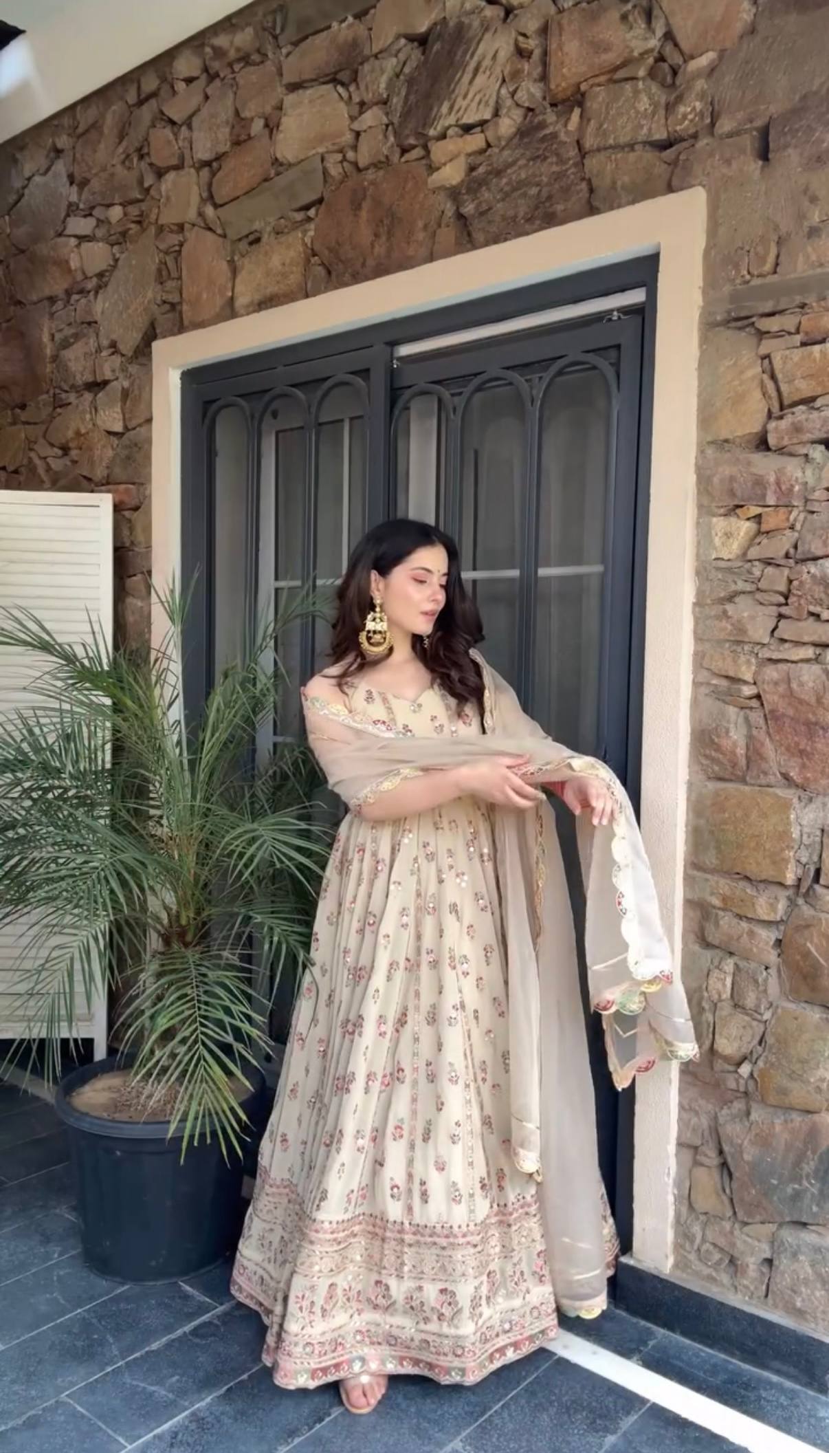 Woman in a beige, embroidered Anarkali gown.