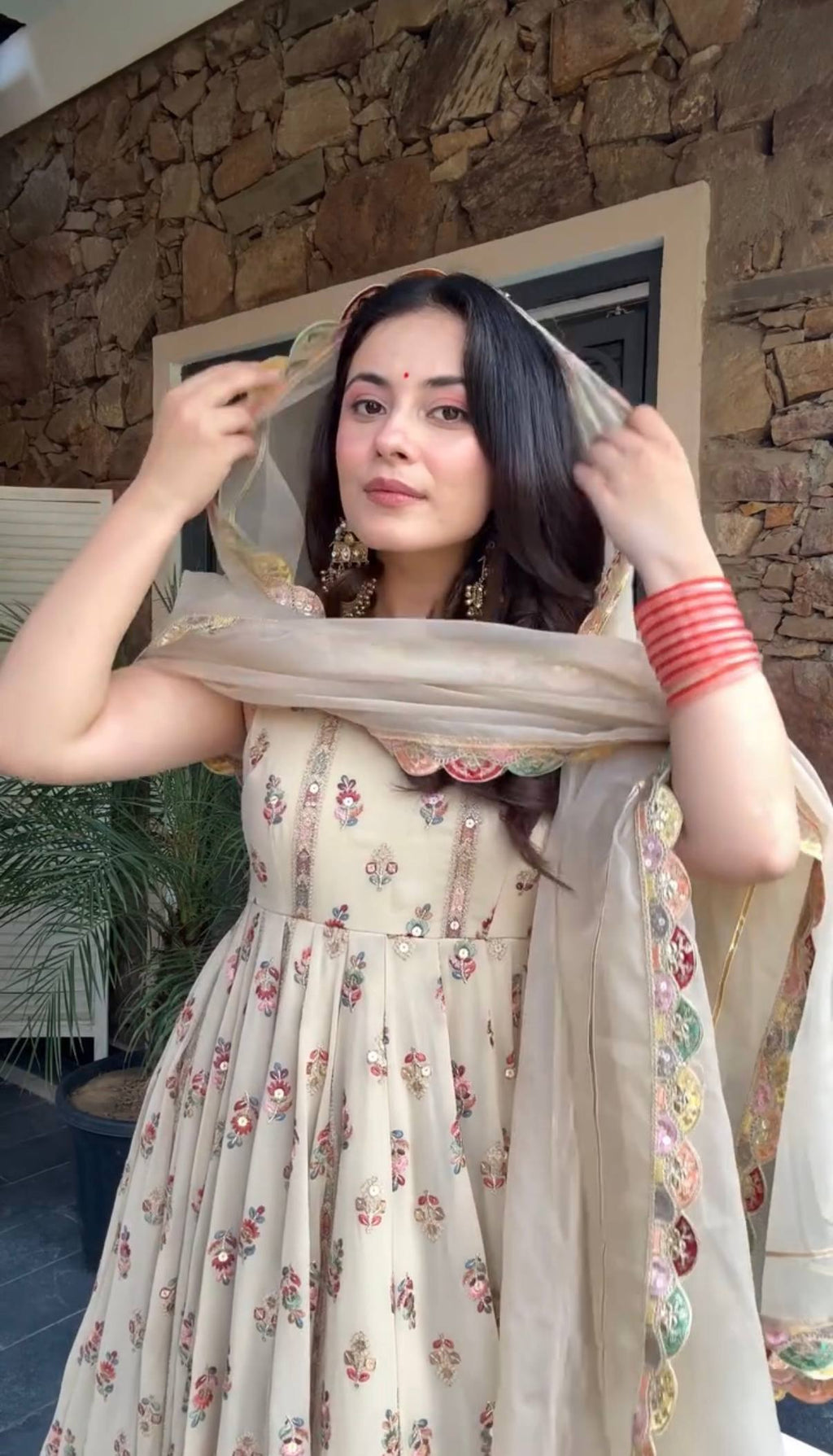 Woman in a beige, embroidered Anarkali gown.