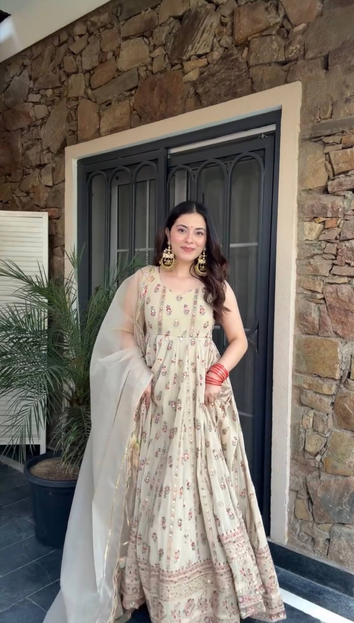 Woman in a beige, embroidered Anarkali gown.